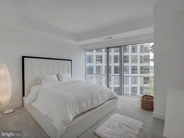 a bedroom with a bed and a large window