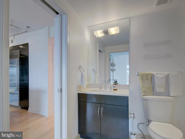 a bathroom with a toilet sink a mirror and vanity