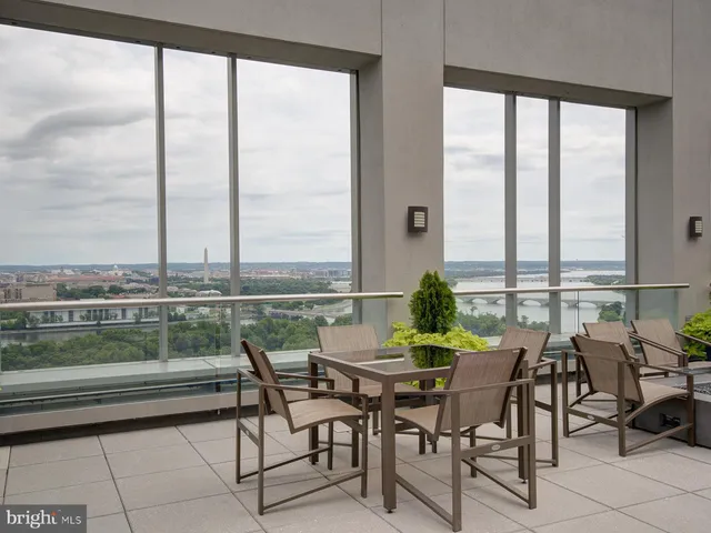 a dining room with furniture and floor to ceiling windows