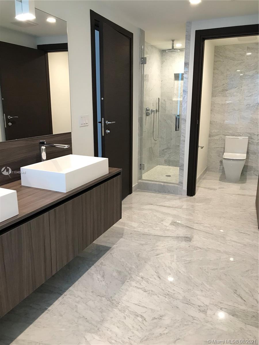 a bathroom with a double sink shower and a mirror