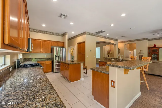 a kitchen with stainless steel appliances granite countertop a sink and a refrigerator