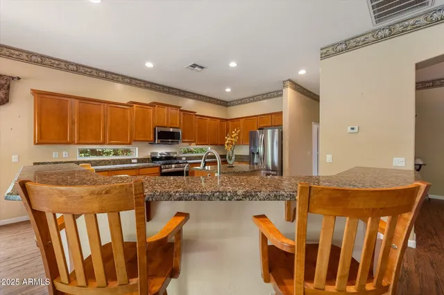 a kitchen with kitchen island a counter top space a sink a stove and a refrigerator