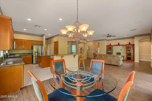 a view of a dining room with furniture a chandelier and wooden floor