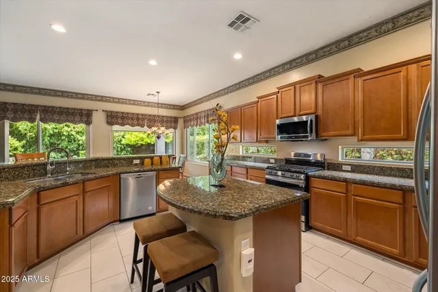 a kitchen with kitchen island granite countertop a sink stove and microwave