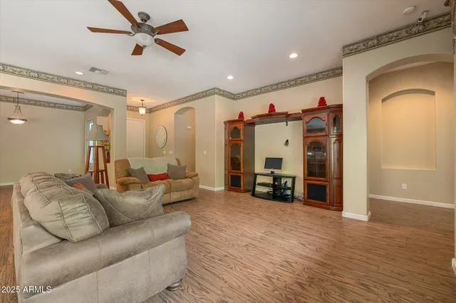 a living room with furniture and a ceiling fan