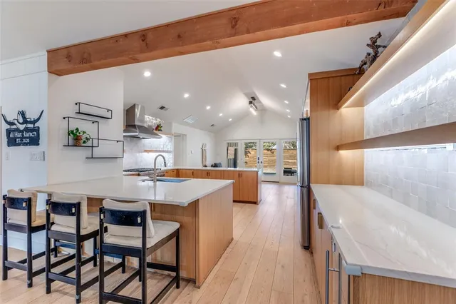 a dining hall with stainless steel appliances kitchen island granite countertop a sink and cabinets
