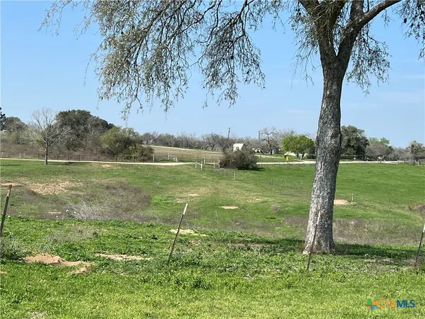 a view of a lake with a big yard and large trees