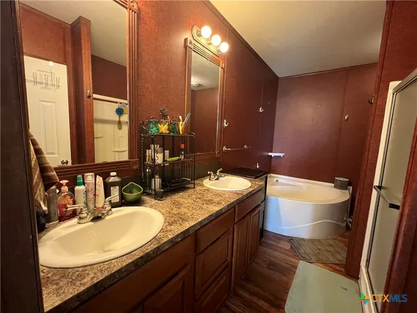 a bathroom with a granite countertop sink a toilet a mirror and bathtub
