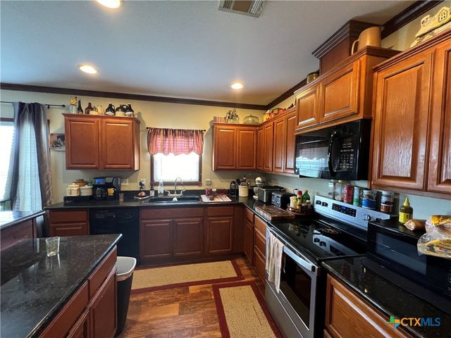 a kitchen with stainless steel appliances granite countertop sink stove and refrigerator