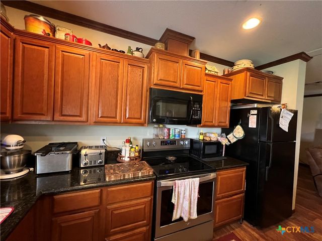 a kitchen with stainless steel appliances granite countertop a refrigerator and a stove top oven