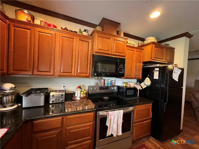 a kitchen with stainless steel appliances granite countertop a refrigerator and a stove top oven