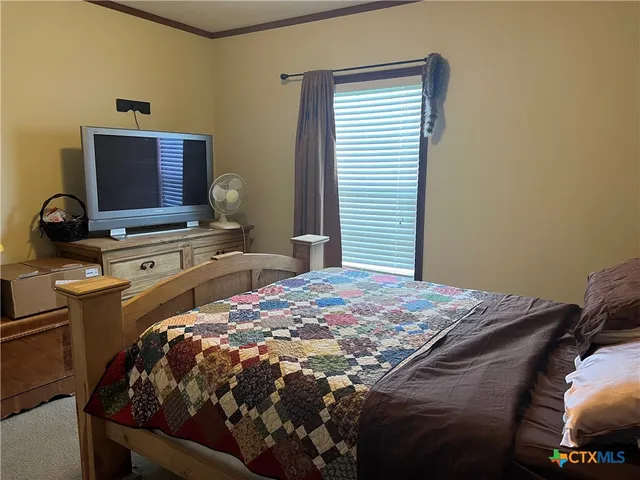 a bed sitting in a bedroom next to a window