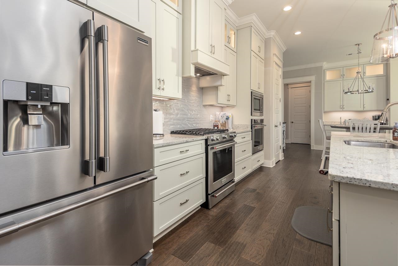 458 South Shea Road Collierville, TN 38017 - Photo 12 of 27 Kitchen featuring dark wood-type flooring, white cabinetry, decorative light fixtures, and stainless steel appliances