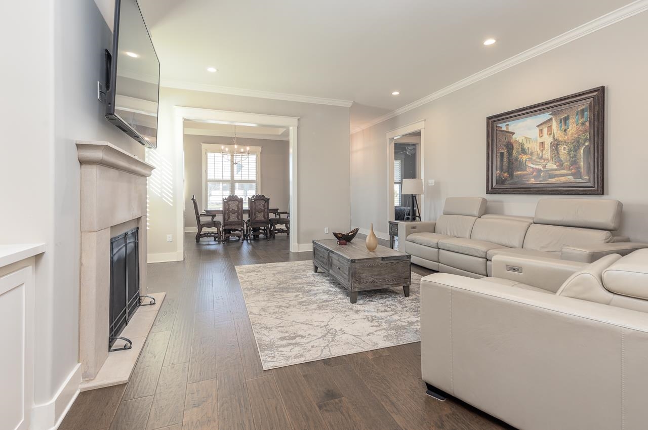458 South Shea Road Collierville, TN 38017 - Photo 13 of 27 Living room with an inviting chandelier, ornamental molding, and dark wood-type flooring