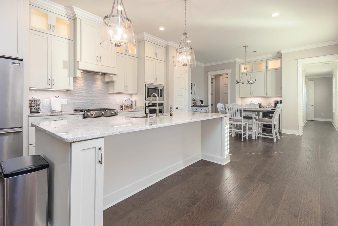 458 South Shea Road Collierville, TN 38017 - Photo 14 of 27 Kitchen featuring dark wood-type flooring, stainless steel appliances, a center island with sink, decorative light fixtures, and white cabinets