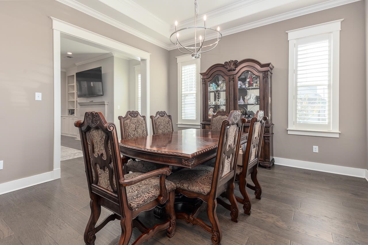 458 South Shea Road Collierville, TN 38017 - Photo 7 of 27 Dining space with a notable chandelier, a healthy amount of sunlight, ornamental molding, and dark hardwood / wood-style floors