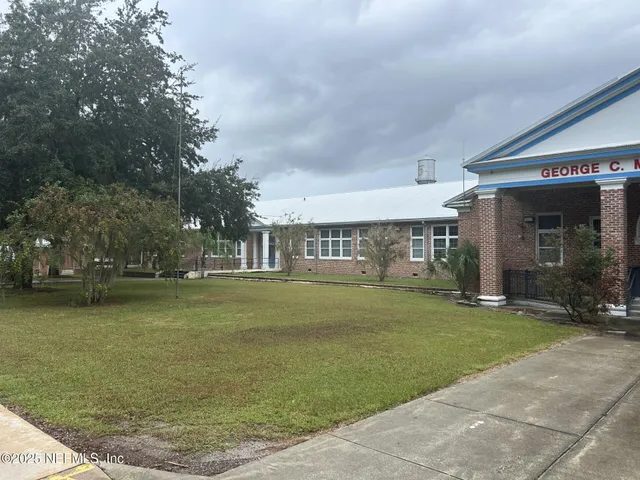 a front view of a house with a yard and trees