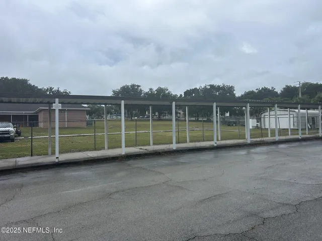 a view of a kitchen with kitchen island granite countertop a sink and a refrigerator