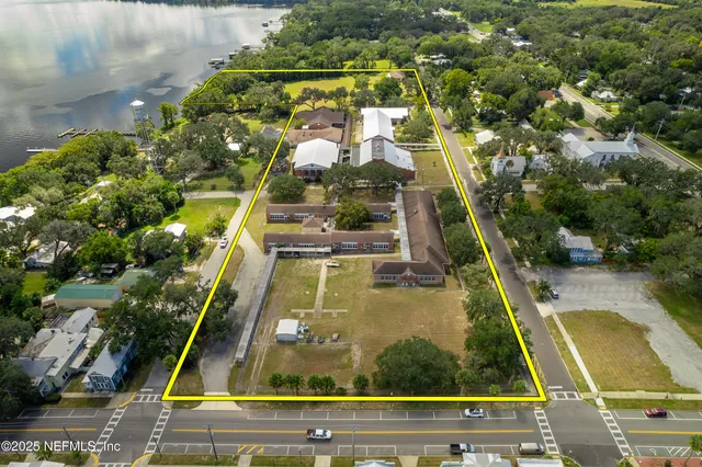 an aerial view of a house with a garden and lake view