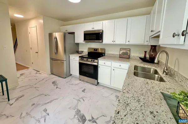 a kitchen with stainless steel appliances granite countertop a stove a sink and a microwave
