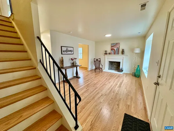 a view of a livingroom with wooden floor and a fireplace