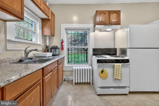 a kitchen with a stove a refrigerator and a sink