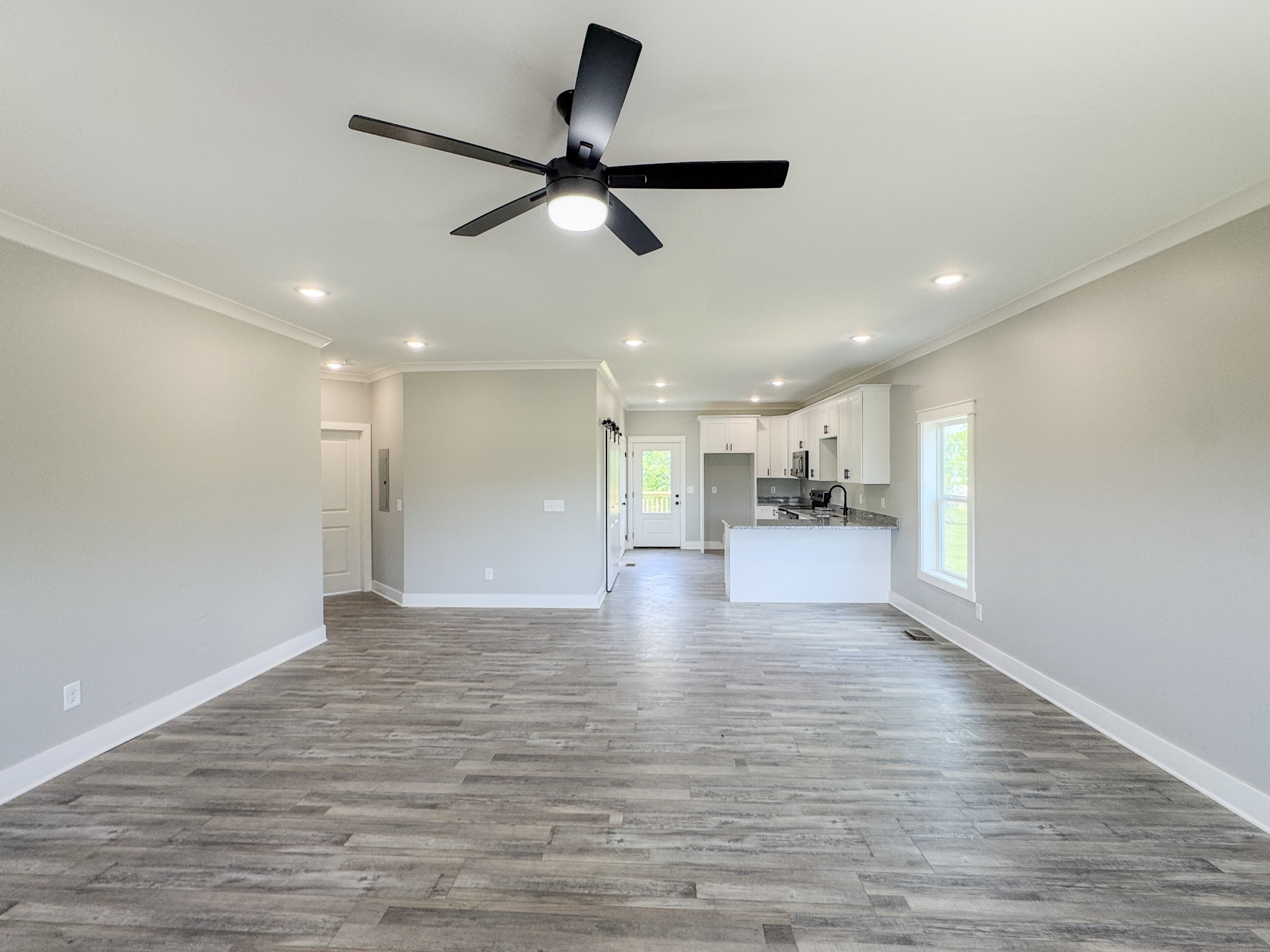 181 Rock House Hollow Road Bethpage, TN 37022 - Photo 13 of 51 a view of an empty room and kitchen with wooden floor