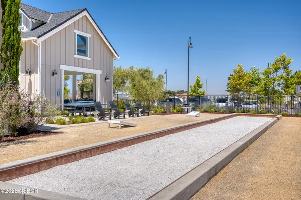 a front view of a building with outdoor seating and plants