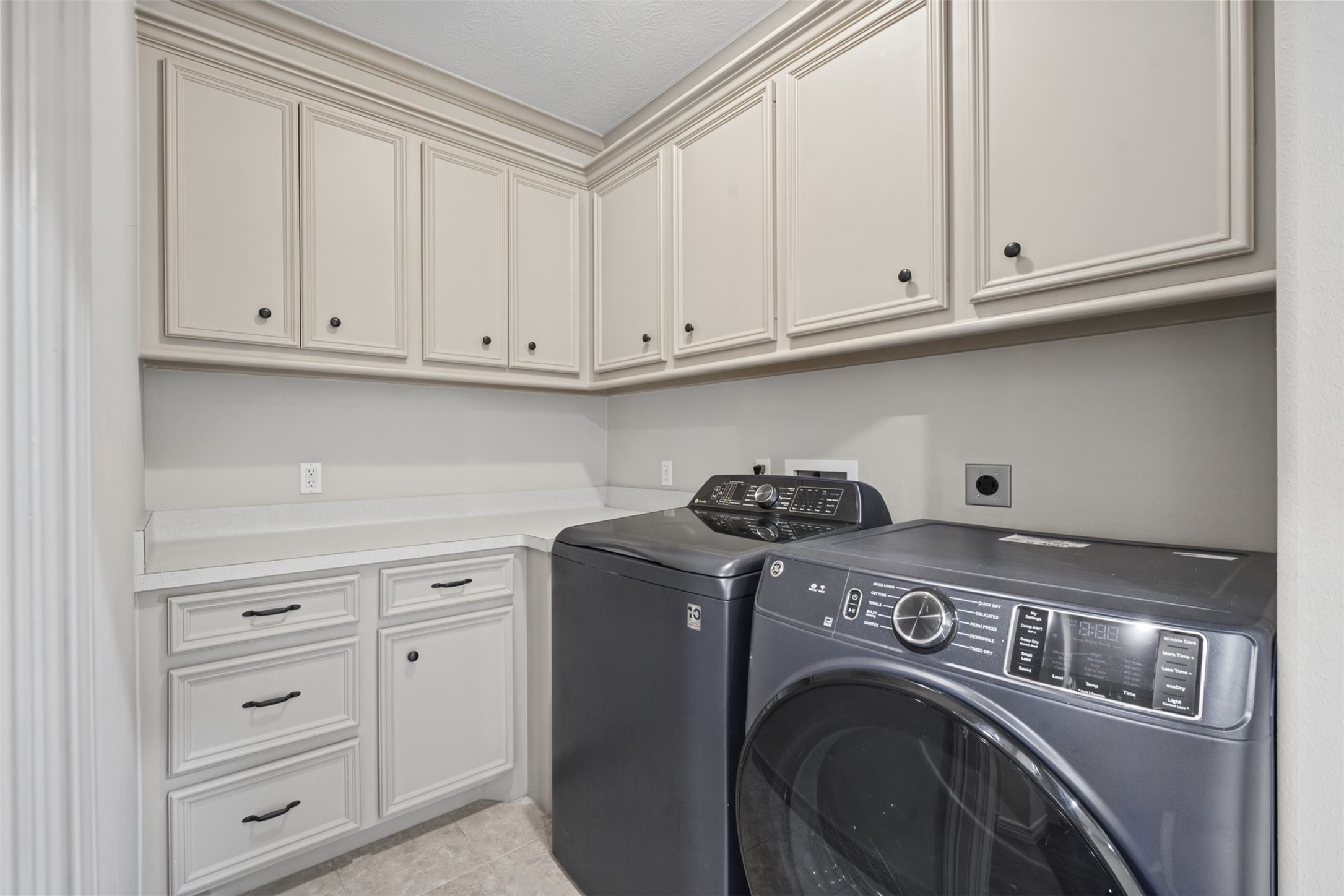 25119 Arcane Court Spring, TX 77389 - Photo 29 of 50 Even The Every Day Spaces Impress! Designed for style and efficiency, the laundry room is accessible from the primary suite and the main hallway. It features tile flooring, abundant upper and lower cabinetry, and a folding counter. Washer and dryer included!