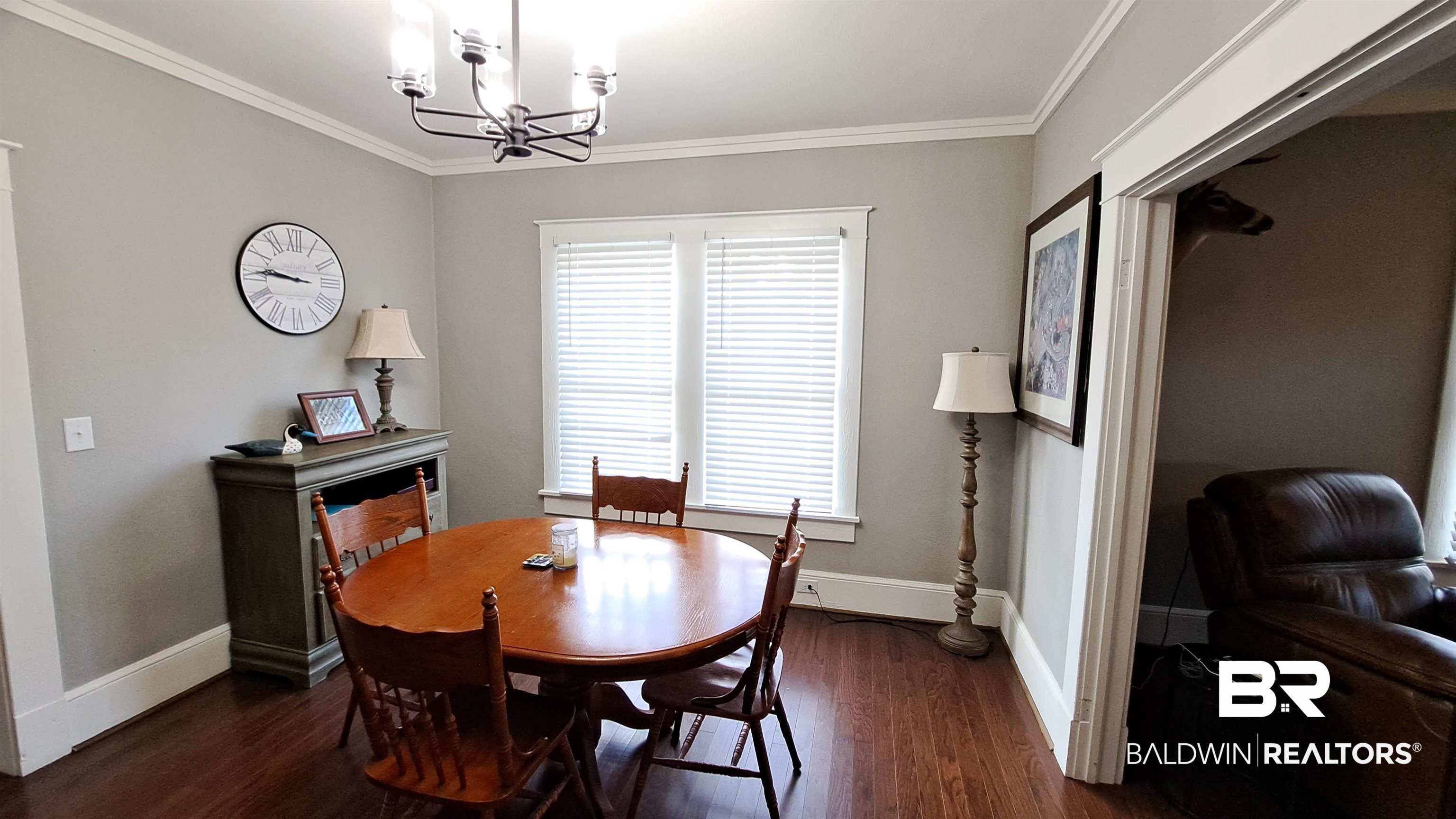 110 South Main Street Evergreen, AL 36401 - Photo 18 of 27 Dining area featuring wood-finish flooring, a contemporary chandelier, and a window with blinds