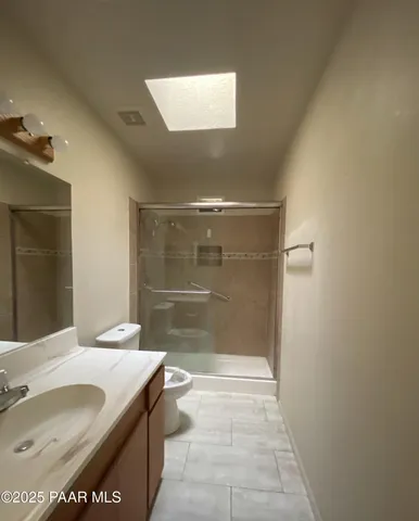 a bathroom with a granite countertop sink a toilet and shower