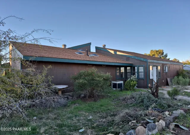 a view of a house with a backyard and plants