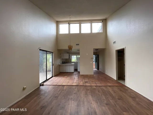 a view of empty room with wooden floor and window