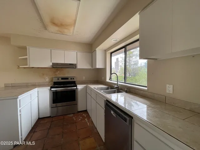 a kitchen with a sink stove top oven and cabinets
