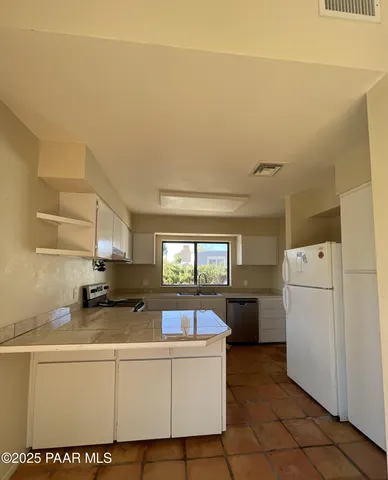 a room with a white cabinets and white appliances