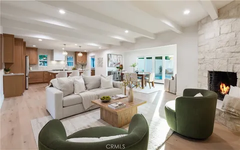 a kitchen with stainless steel appliances granite countertop a kitchen island a table and chairs in it