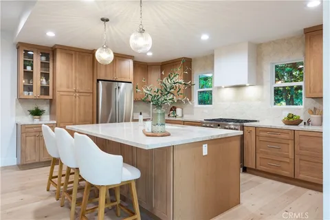 a kitchen with kitchen island granite countertop a sink cabinets and stainless steel appliances