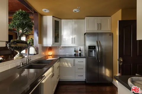 a kitchen with stainless steel appliances granite countertop a sink a stove and a refrigerator