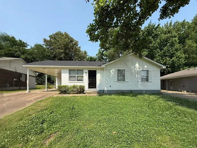 a front view of house with a garden and trees