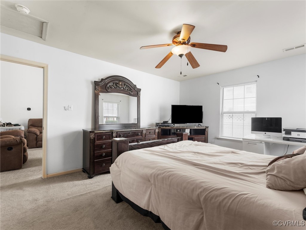 Bedroom featuring light carpet, ceiling fan, and a