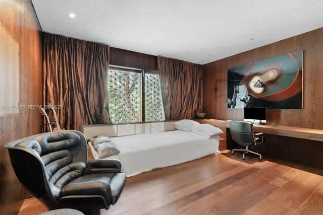 a bedroom with a bed and a large window