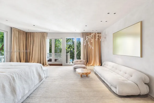 a spacious bedroom with a bed and glass walk in closet