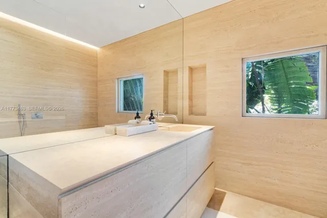 a en suite bathroom with a granite countertop sink and a large mirror