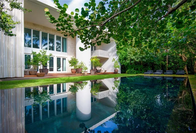 an aerial view of a house with yard and swimming pool