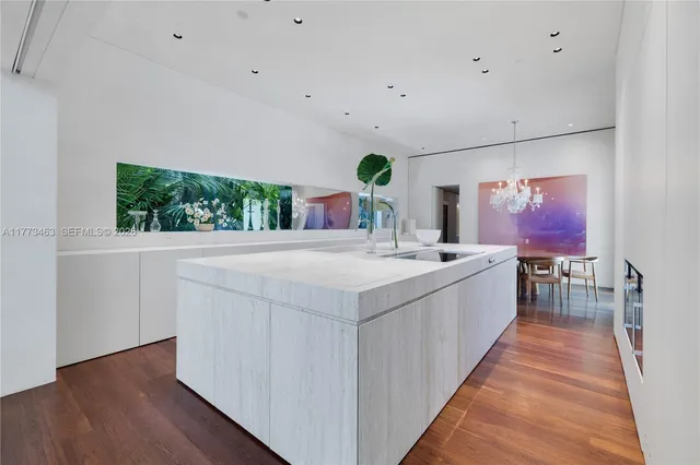 a view with living room with stainless steel appliances kitchen island furniture and wooden floor