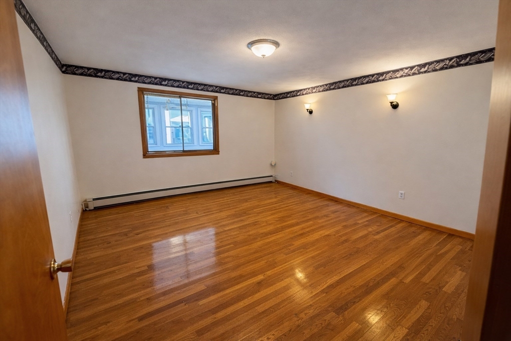 198 Washington Street, Unit 1 Somerville, MA 02143 - Photo 11 of 15 a view of an empty room with wooden floor and a window