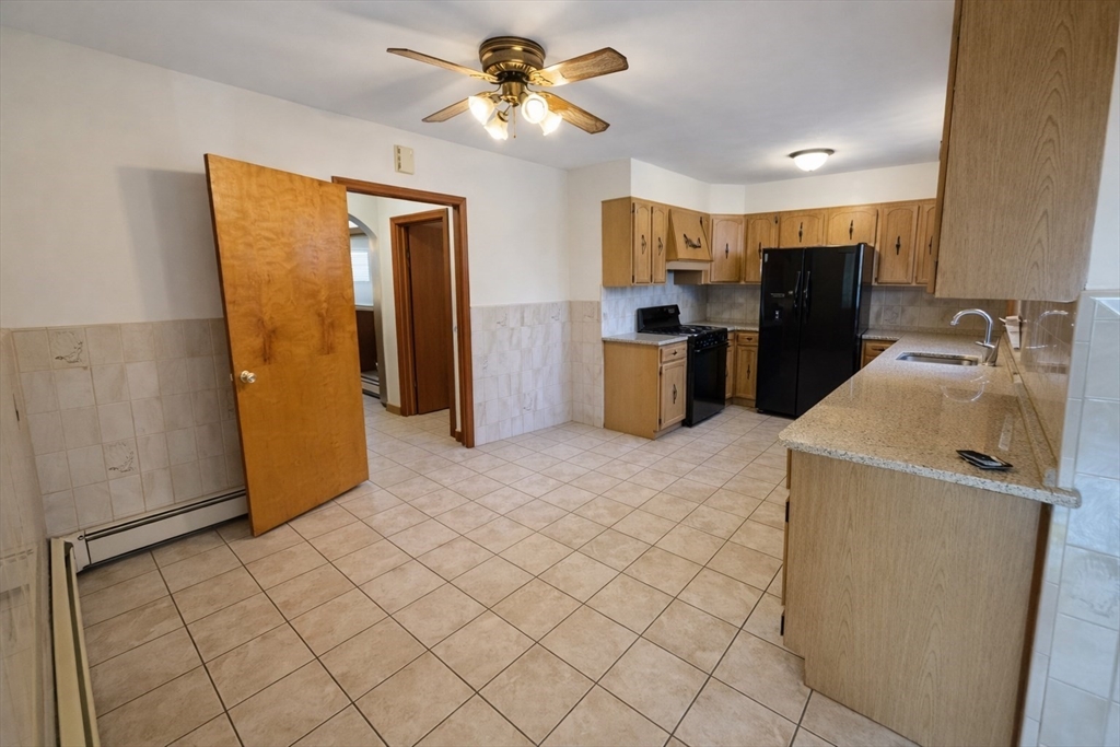 198 Washington Street, Unit 1 Somerville, MA 02143 - Photo 4 of 15 a kitchen with stainless steel appliances a refrigerator a sink a stove top oven a counter space and cabinets