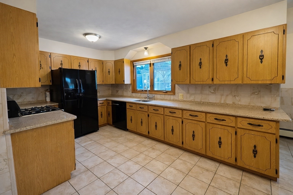 198 Washington Street, Unit 1 Somerville, MA 02143 - Photo 6 of 15 a kitchen with stainless steel appliances granite countertop a refrigerator and a stove