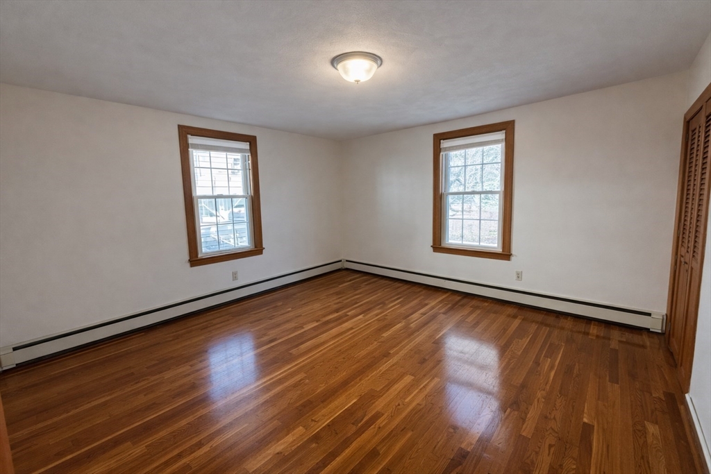 198 Washington Street, Unit 1 Somerville, MA 02143 - Photo 7 of 15 a view of an empty room with wooden floor and a window