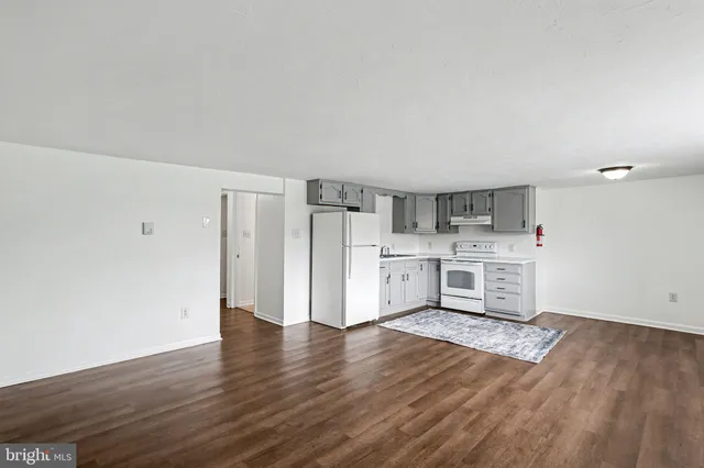 a view of kitchen with stainless steel appliances wooden floor